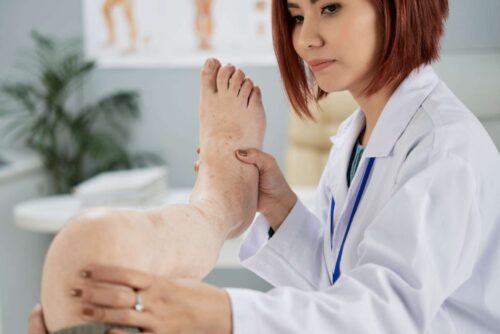 Chiropractor checking mobility and elasticity of joints of senior patient